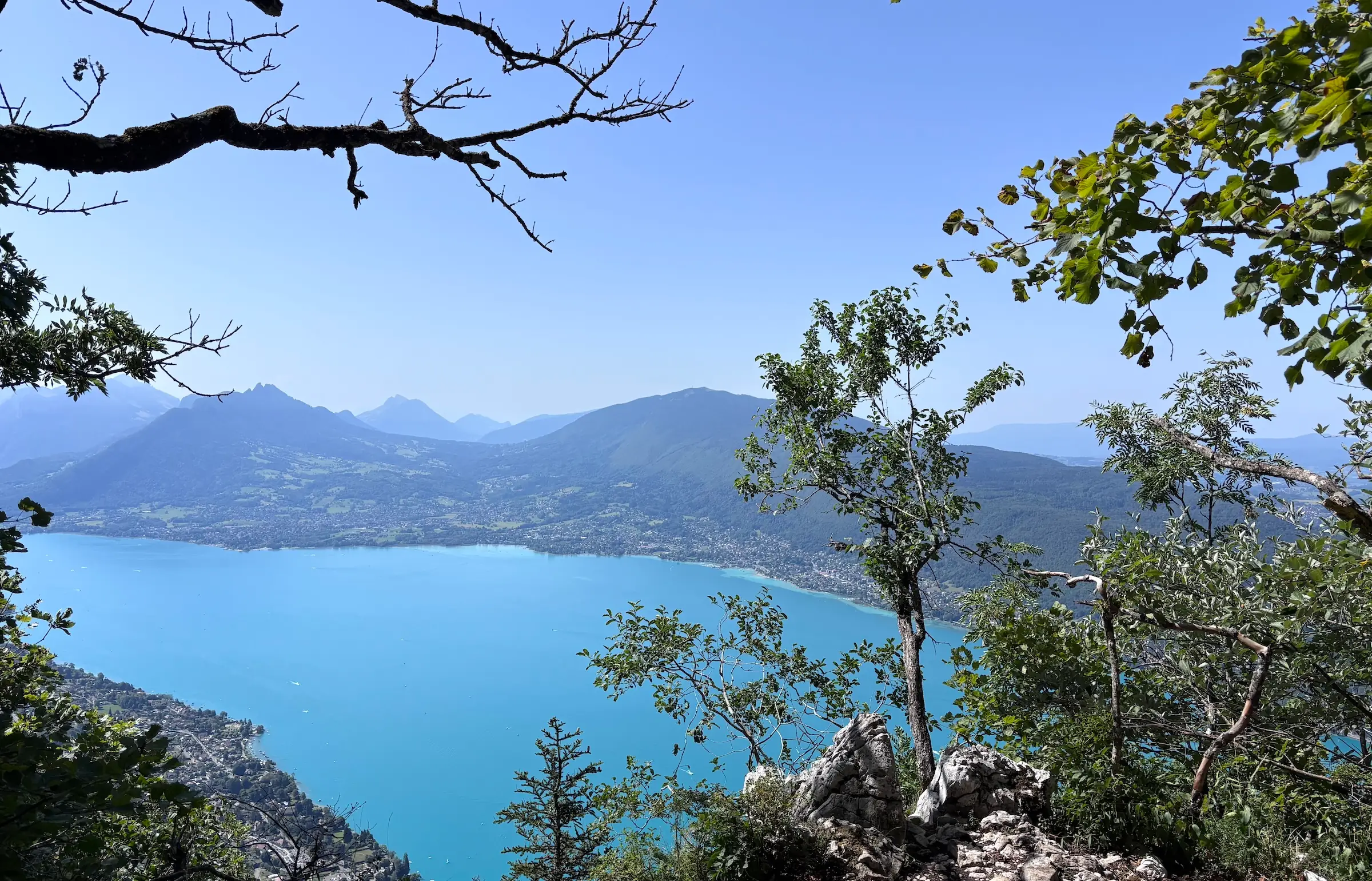 Vue panoramique sur le lac d'Annecy depuis un sentier de trail en montagne